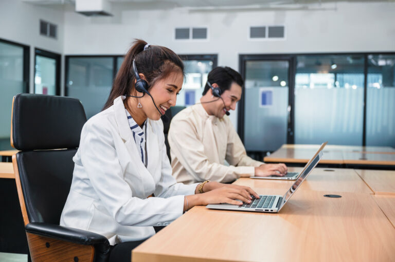 Young asian operator woman agent with headsets working customer service in a call center